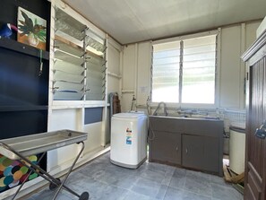 A compact kitchen with a refrigerator, sink, and a window.