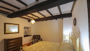 Un dormitorio con cama, cómoda, espejo y ventilador de techo.