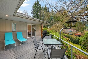 A deck with outdoor seating, a grill, and a lantern. - Relaxing Lakeside Bungalow,Steps to Lake Samish Park to enjoy lake activities (Bellingham)