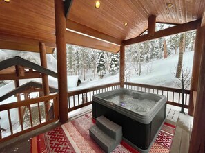 A wooden deck with a hot tub, a staircase, and a view of a snowy forest. - Mountain Getaway- Hot Tub, Hiking, 5mins to Ski Resort (Durango)