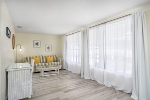 A living room with a sofa, a coffee table, and a wicker side table. - Large Home | Dog OK | Heated Pool | Close to Beach (Sarasota)