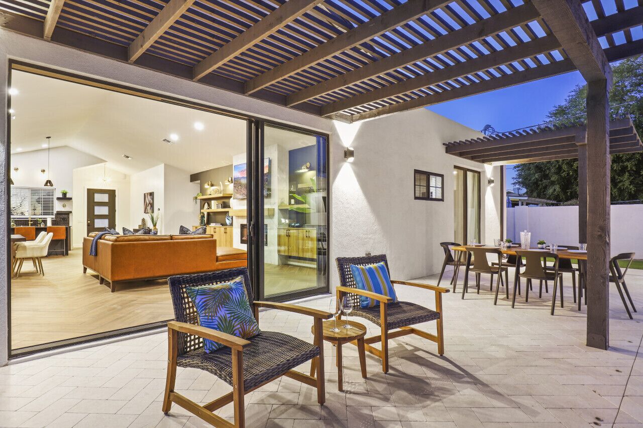 Un espacio habitable abierto con cocina, comedor y un patio con mobiliario de exterior.