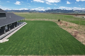 A house with a large lawn and a mountain backdrop. - Alpenglo Farm with Event Space and Parking (Driggs)