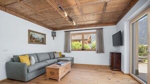 Un salon avec un canapé gris, une table basse en bois et un téléviseur.