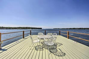 A wooden deck with a table and chairs overlooking a body of water. - Lakefront Mabank Gem w/ Sunset Views: Pets Welcome (Mabank)
