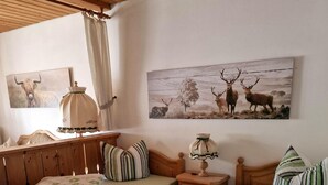 Una habitación acogedora con una cama de madera, una mesita de noche de madera, una lámpara y dos cuadros en la pared.