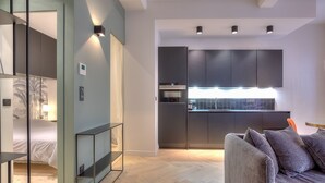 A modern interior with a kitchen, a sofa, and a bed with a glass partition. - Charming Flat Saleya OLD Town (Nice)