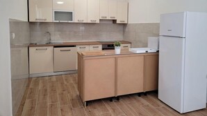 A modern kitchen with light-colored cabinets, a built-in microwave, a sink, and a white refrigerator. - Vacation home Kevin by Interhome (Orebić/Viganj)