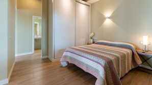 A bedroom with a bed, a nightstand, a lamp, and a sliding door closet.