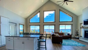 A spacious living area with a large island kitchen, a cozy seating area, and a fireplace.