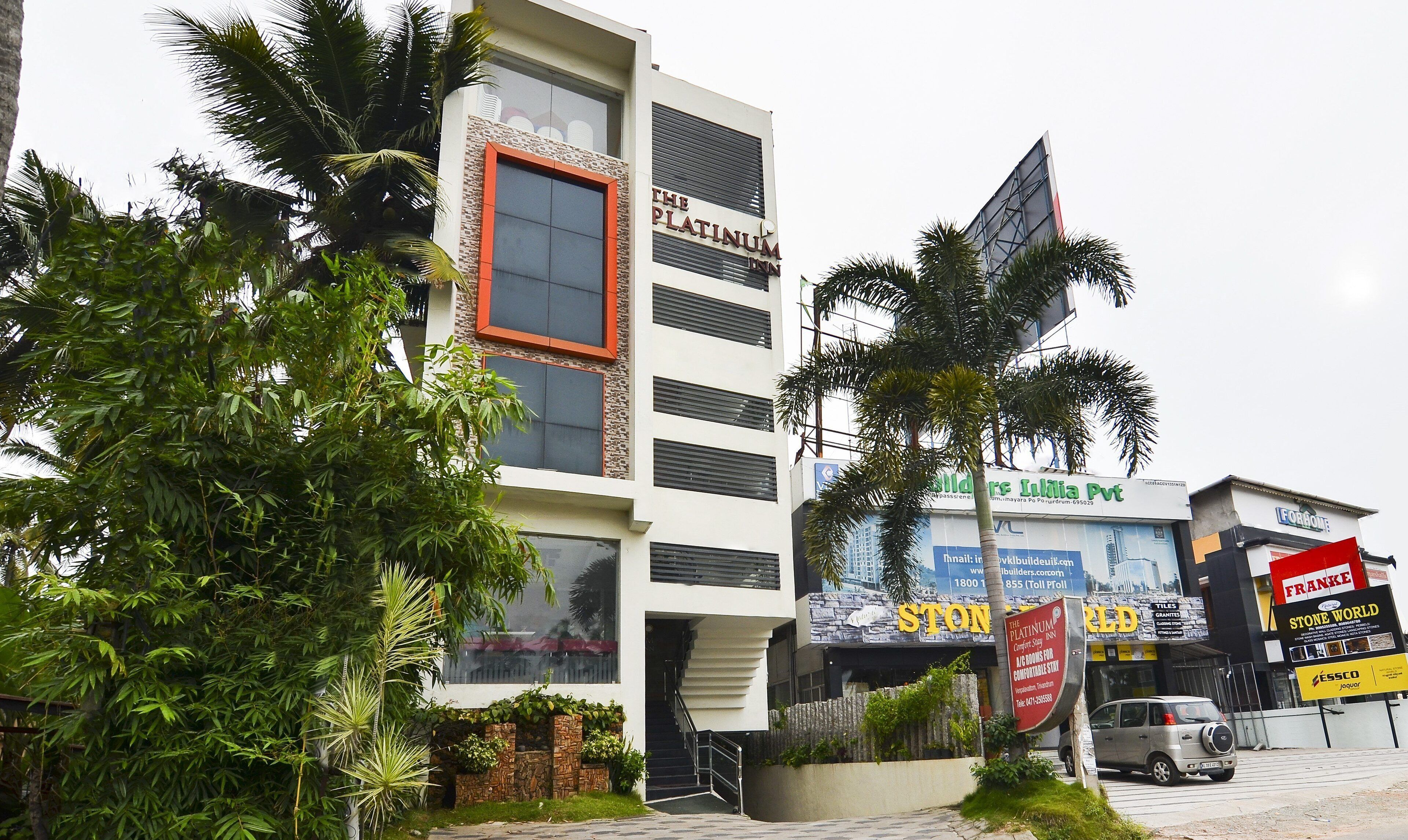 A hotel with a modern facade, multiple balconies, and a prominent sign for 'The Platinum Inn'.