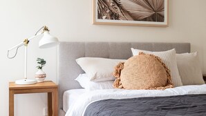 A neatly arranged bedroom with a bed, a bedside table with a lamp, and a framed picture on the wall. - Pet Friendly - Elwood Sanctuary - walking distance to the beach (Elwood)