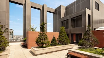 A modern building with a courtyard featuring benches and small trees.