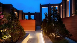 A modern building with a geometric design, featuring a central pathway and surrounding greenery. - G3 Hotel Chungmuro (Seoul)