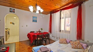 A room with a wooden ceiling, a dining table with chairs, a bed with pillows, and a window with curtains. - Apartment 2192/56814 (Istria - Pula), 3000m from the beach (Pula)