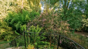 A garden with a metal staircase and potted plants. - Le Moulin du Pont (Mezin)