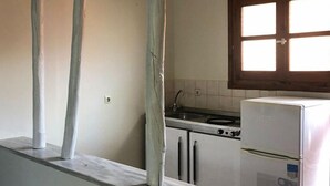 Una cucina con mobili bianchi, un fornello e un frigorifero.