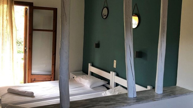Una camera da letto con un letto, una testiera in legno, un comodino e un punto luce a parete.