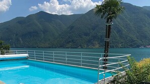 A swimming pool with a view of mountains and a clear sky. - Lugano Blue Marine On Lake Shore (Lugano)