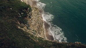 A coastal town with a prominent cliff and an arch formation. - Clos Céleste - Campagne d'Etretat (Ecrainville)
