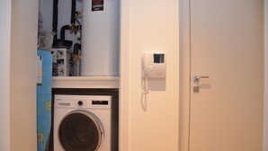 A laundry room with a washing machine, a dryer, and a telephone. - LARPOTE LODGE - LUTON (LUTON)