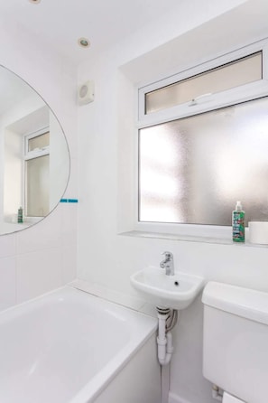 Ein Badezimmer mit einer Badewanne, einem Waschbecken und einem Spiegel.