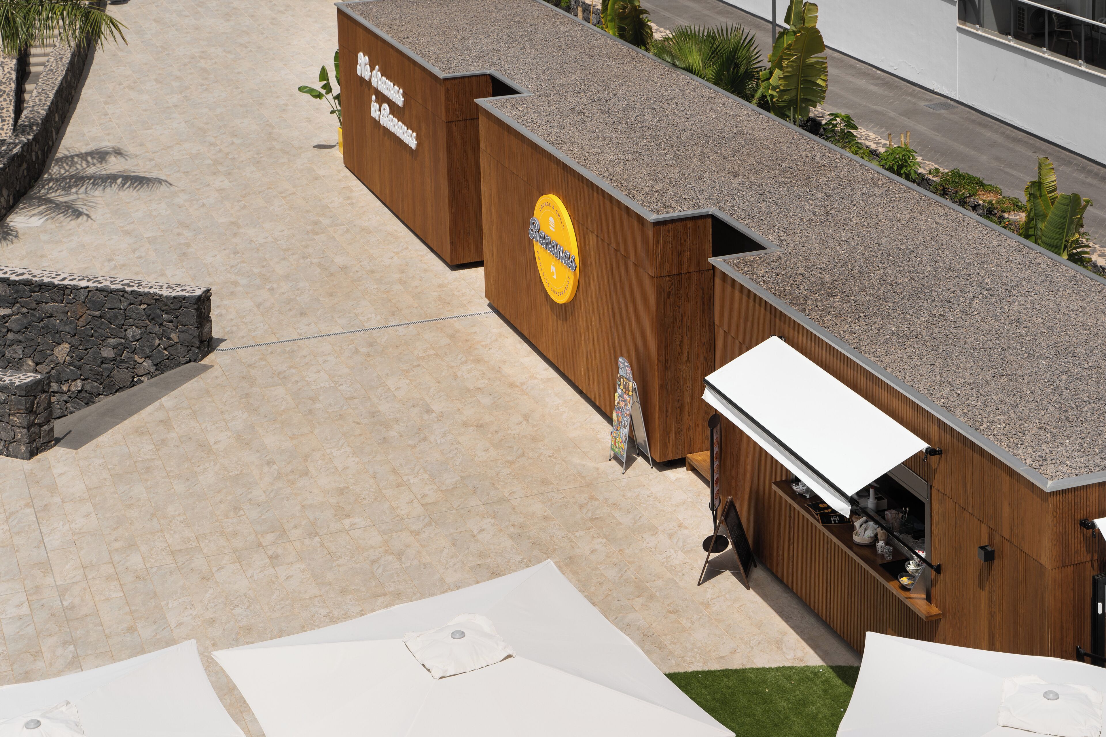 A modern building with a wooden facade and a sign that reads "The Beach Club."