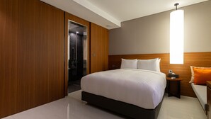 A modern hotel room with a large bed, wooden paneling, a bedside table, and a nightstand. - Topcloud Hotel Iksan (Iksan)