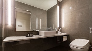 A modern bathroom with a large mirror, a white sink, and a toilet. - Topcloud Hotel Iksan (Iksan)