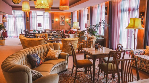 Amplia sala de estar con asientos cómodos, un comedor y vistas a la ciudad.