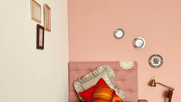 Een slaapkamer met een bed, een stoel en decoratieve wandversiering.