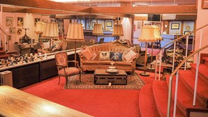 Una sala de estar de estilo vintage con un sofá, sillones y una mesa de centro.