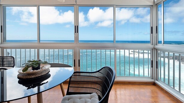 A balcony with a table and chairs, a potted plant, and a view of the sea. - Vacation Home 'Marazul' with Sea View, Balcony & Wi-Fi (Tacoronte)