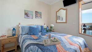 A bedroom with a bed, a nightstand, a tray with cups and saucers, and a window with a view. - Vacation Home 'Marazul' with Sea View, Balcony & Wi-Fi (Tacoronte)