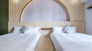 Habitación doble con dos camas, cabecera de madera con diseño circular y pared de color claro.