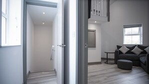 Una sala de estar moderna con un sofá gris, un reposapiés y una mesita auxiliar.