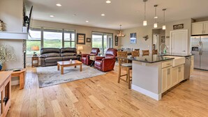 Ein geräumiges Wohnzimmer mit Kamin, Ledersofas und einer Essecke mit Kücheninsel.