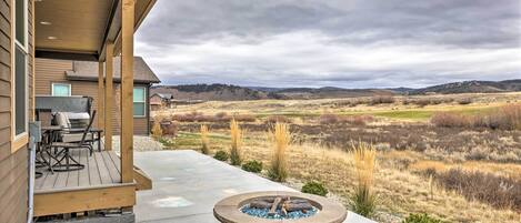 Un espacio al aire libre cubierto con una chimenea, una mesa de patio y sillas.