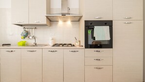 Eine moderne Küche mit Gasherd, Spüle und eingebautem Backofen.