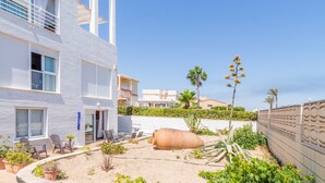 Un bâtiment moderne doté d’un patio, d’un espace extérieur aménagé pour s’asseoir et d’un grand pot décoratif.