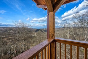 A wooden deck with a clear view of a mountainous landscape.