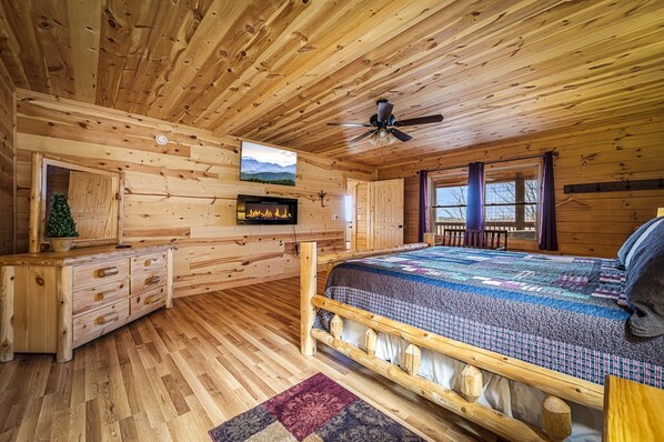 A wooden cabin bedroom with a bed, dresser, TV, fireplace, and windows. - Amazing views , Free tickets to Dollywood,Anakeesta, and other local attractions (Gatlinburg)