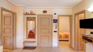 Une chambre d’hôtel comprenant un lit, une télévision, un bureau et une porte donnant sur une autre pièce.