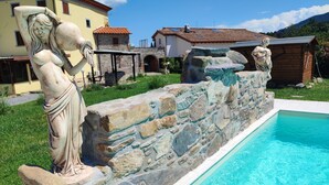 A stone wall with statues, a swimming pool, and houses in the background. - Villa "Giovanna" with Shared Open Pool, Terrace, Garden & Wi-Fi (Capannori)