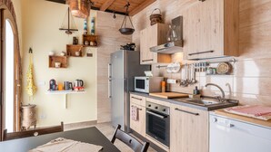 A compact kitchen with wooden cabinets, a stainless steel refrigerator, a microwave, and a sink. - Villa "Giovanna" with Shared Open Pool, Terrace, Garden & Wi-Fi (Capannori)