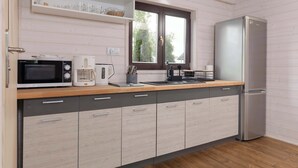 A modern kitchen with a microwave, coffee maker, and refrigerator. - Apartment with Garden | Parking, 4.9 km to the Beach (Powiat koszaliński)
