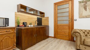 A compact kitchen with wooden cabinets, a microwave, and a sink.