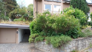 Ein Wohngebäude mit einer Steinmauer, einem gepflasterten Auffahrtsweg und einer Garage.