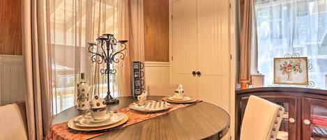 A dining area with a round table, chairs, and a decorative centerpiece.