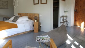 Un dormitori amb llit, una taula de nit, una làmpada i una revista sobre una taula petita.